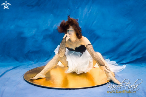 A human | woman sitting on a gold platter
